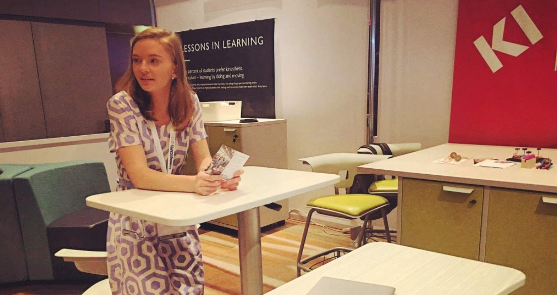 Amanda standing at a table in an interactive learning space